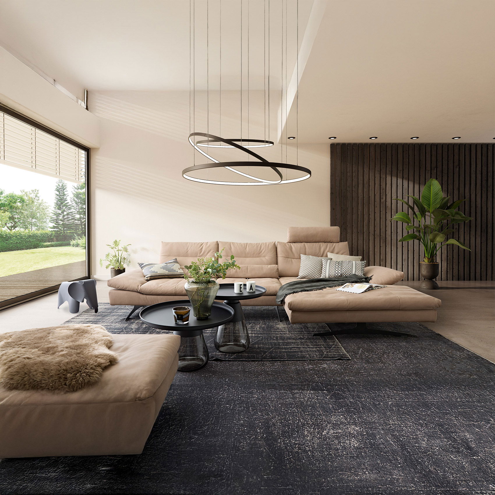 Modernes Wohnzimmer mit beigem Ecksofa, runden Couchtischen, Teppich und großer Pendelleuchte