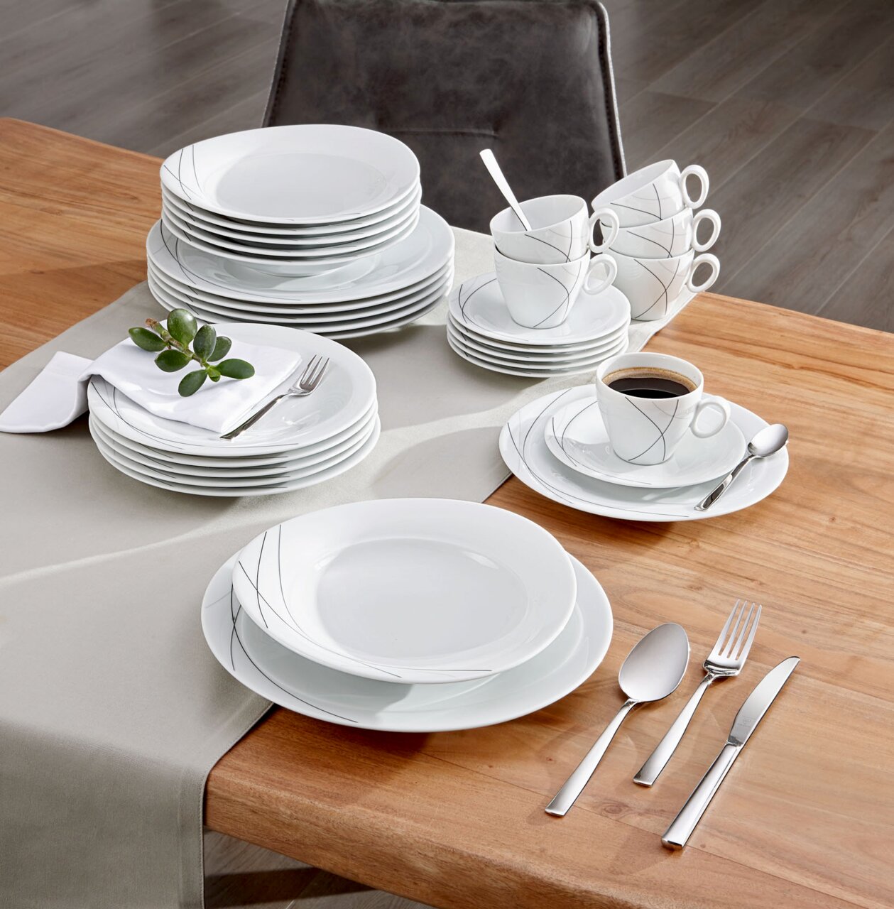 Elegantes Kombiservice Trio Highl. 30-teilig auf einem Holztisch, von oben fotografiert, mit Tellern, Tassen und Besteck in modernem Design.