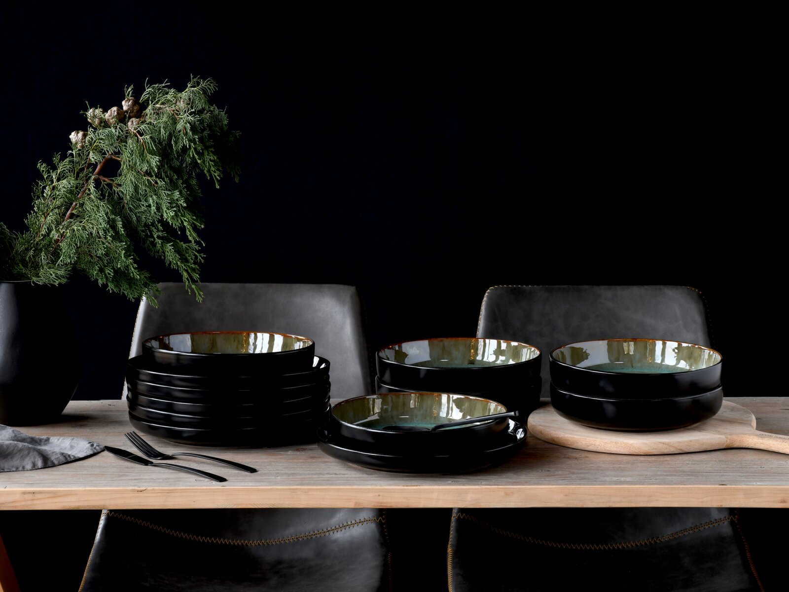 Creatable Tafelservice 12-tlg NORDIC FJORD Elegantes 12-teiliges Tafelservice in Schwarz mit glänzender Innenseite, auf einem Holztisch arrangiert, seitliche Perspektive.