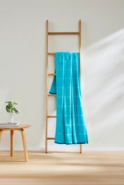 Türkises Strandtuch 90x180cm auf einer Holzleiter, seitliche Perspektive