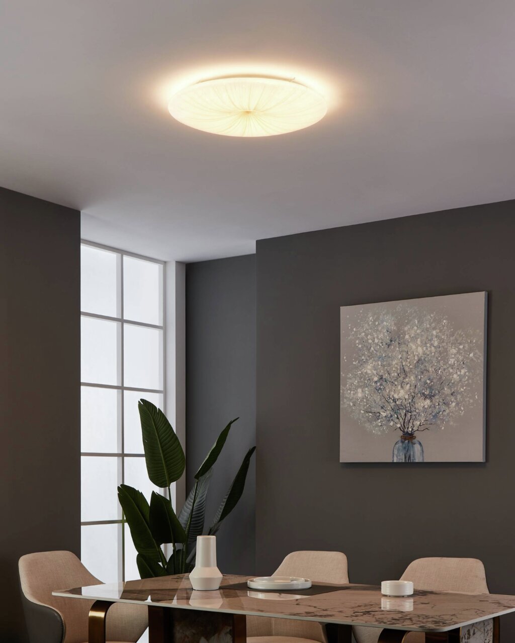 LED-plafondlamp NIEVES 1 in een moderne woonkamer, van onderaf gezien, met zacht, warm licht dat de ruimte verlicht.