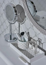 Porzellanbecher in Weiß mit grauem Muster, gefüllt mit einem Kamm und einem Pinsel, auf einem dekorativen Tablett in einem Badezimmer, seitliche Perspektive