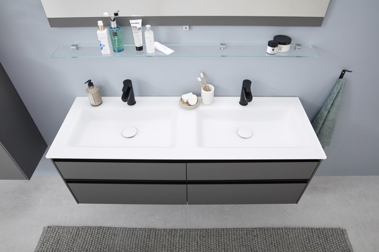 Moderne Badkombination mit Doppelwaschbecken, schwarzer Armatur und Stauraum, aus der Vogelperspektive fotografiert.