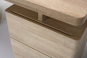 Nahaufnahme eines Schreibtisches aus hellem Holz mit abgerundeten Kanten, seitliche Perspektive