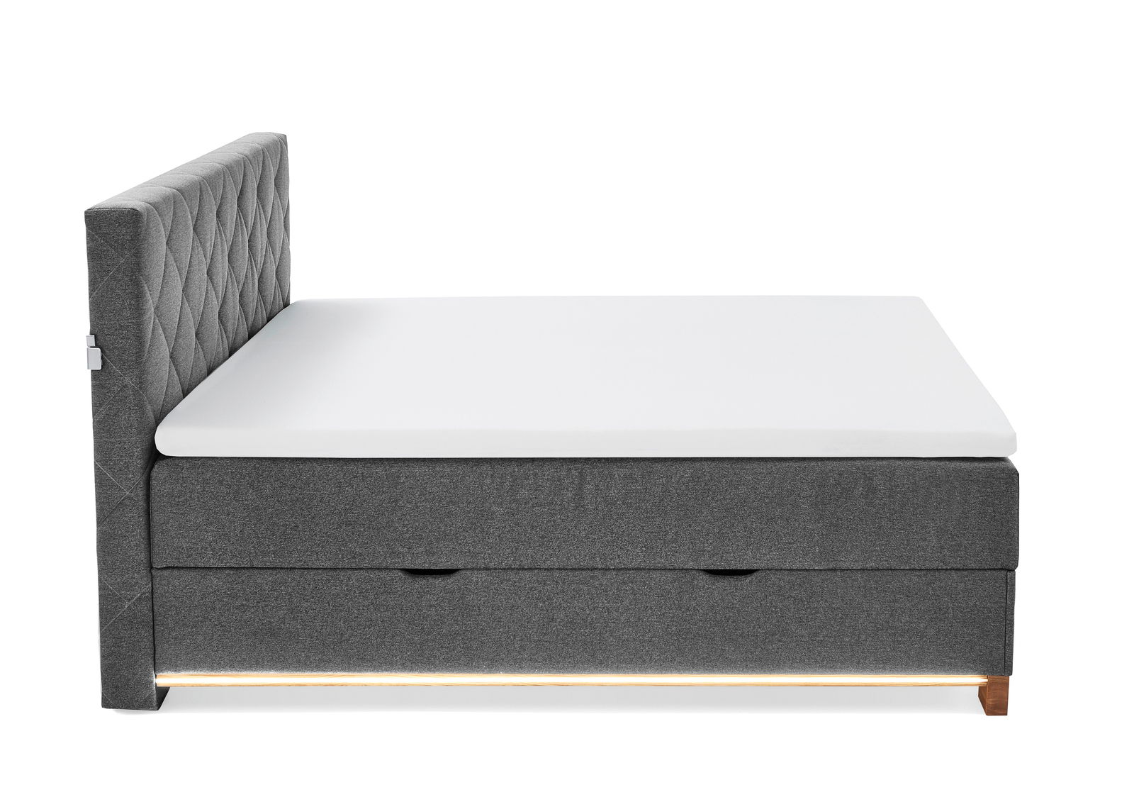 Seitenansicht eines grauen Boxspringbetts mit gestepptem Kopfteil und weißer Matratze.