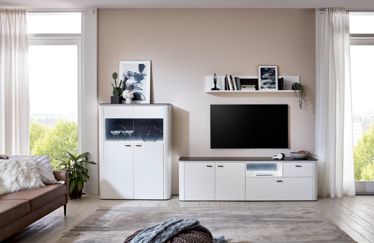 Zurbrüggen TV-Unterteil WAVE Modernes Wohnzimmer mit TV-Unterteil in Weiß, dekoriert mit Pflanzen und Kunstwerken, seitliche Perspektive.