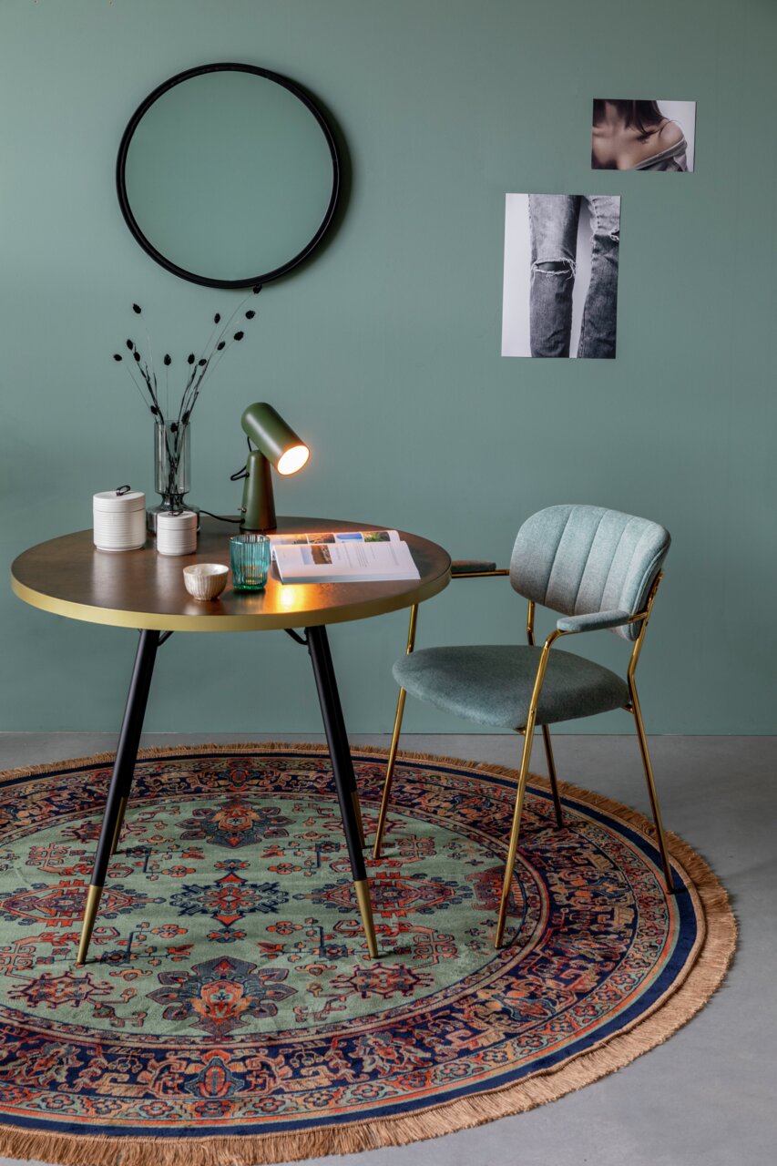 Runder Teppich mit orientalischem Muster in einem stilvoll eingerichteten Raum, aus der Vogelperspektive betrachtet.