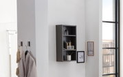 Schwarzes Hängeregal an einer weißen Wand, frontal fotografiert, mit mehreren Fächern, die dekorative Gegenstände und Pflegeprodukte enthalten.
