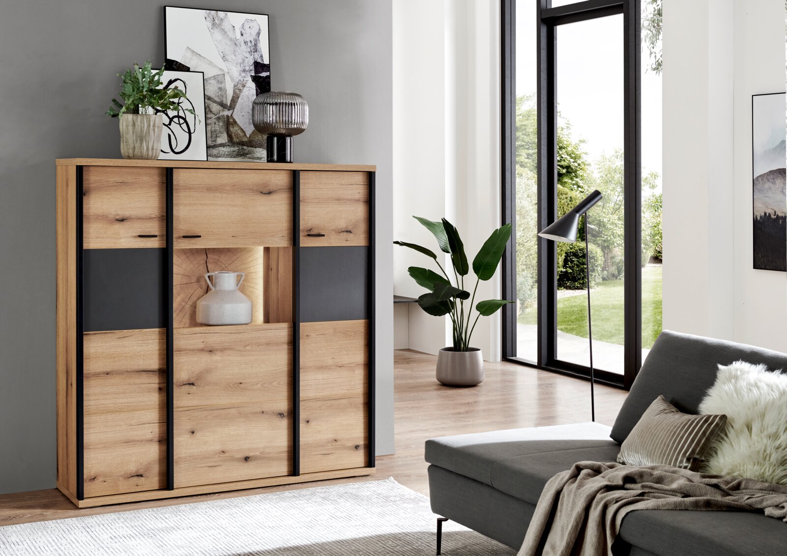 XORA Hoogkast MELO Moderne houten ladekast met zwarte accenten en een open vak, geplaatst in de woonkamer, vooraanzicht