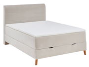 Beiges Boxspringbett mit gestepptem Kopfteil und Holzfüßen, seitliche Perspektive