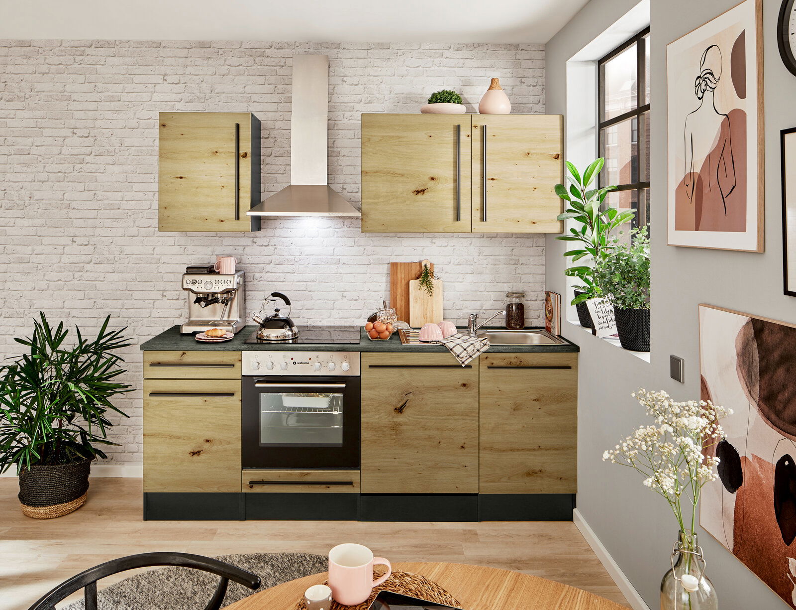 Moderne Küchenzeile in Holzoptik mit Herd, Dunstabzugshaube und Spüle, umgeben von Pflanzen und Dekorationen, aus der Perspektive eines gemütlichen Wohnraums.