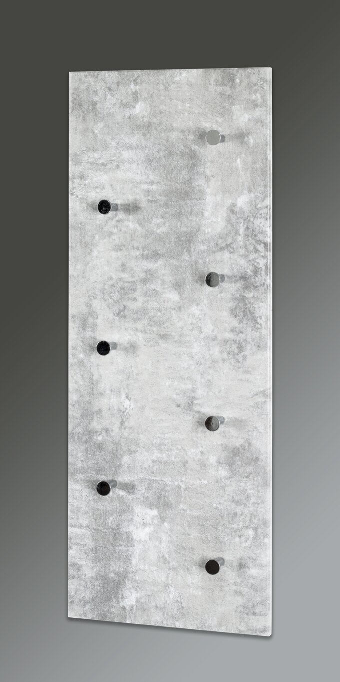 Frontale Ansicht einer grauen Wandgarderobe im Beton-Look mit mehreren runden Haken in Schwarz und Grau, leicht schräg von vorn fotografiert