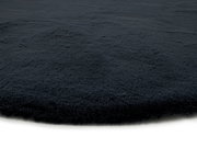 Nahaufnahme eines dunkelgrauen Fellteppichs mit weicher Textur, seitliche Perspektive