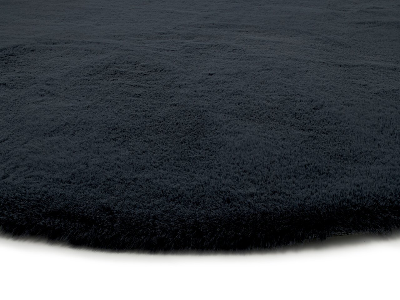 Nahaufnahme eines dunkelgrauen Fellteppichs mit weicher Textur, seitliche Perspektive