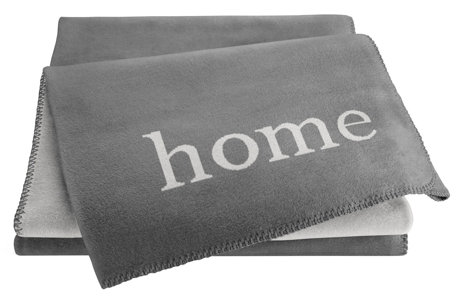 Graue Wohndecke mit dem Wort 'home' in weißer Schrift, aus einer leicht seitlichen Perspektive fotografiert.