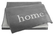 Graue Wohndecke mit dem Wort 'home' in weißer Schrift, aus einer leicht seitlichen Perspektive fotografiert.