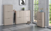 Moderne Schuhschränke in Beige mit hochglänzenden Fronten im Flur, bestehend aus hohem Schrank, breiter Kommode und schmalem Schrank, Frontansicht in leichter Perspektive von schräg vorn