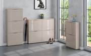 Moderne Schuhschränke in Beige mit hochglänzenden Fronten im Flur, bestehend aus hohem Schrank, breiter Kommode und schmalem Schrank, Frontansicht in leichter Perspektive von schräg vorn