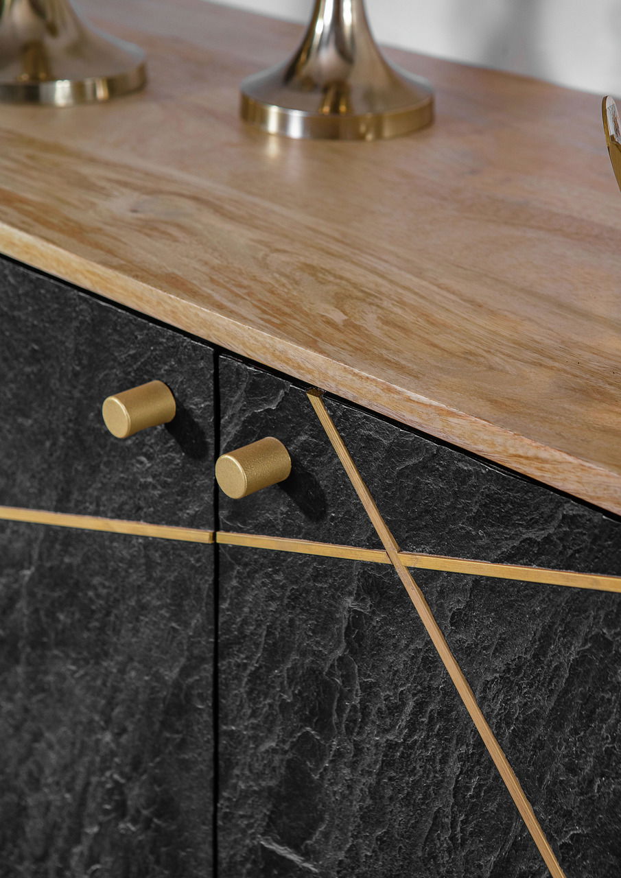 Nahaufnahme einer Kommode mit schwarzer Steinoptik und goldenen Griffen, von oben betrachtet.