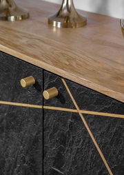 Nahaufnahme einer Kommode mit schwarzer Steinoptik und goldenen Griffen, von oben betrachtet.