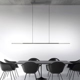 Moderne Pendelleuchte PURE Surface in minimalistischem Design, von der Seite betrachtet, über einem Esstisch mit schwarzen Stühlen.