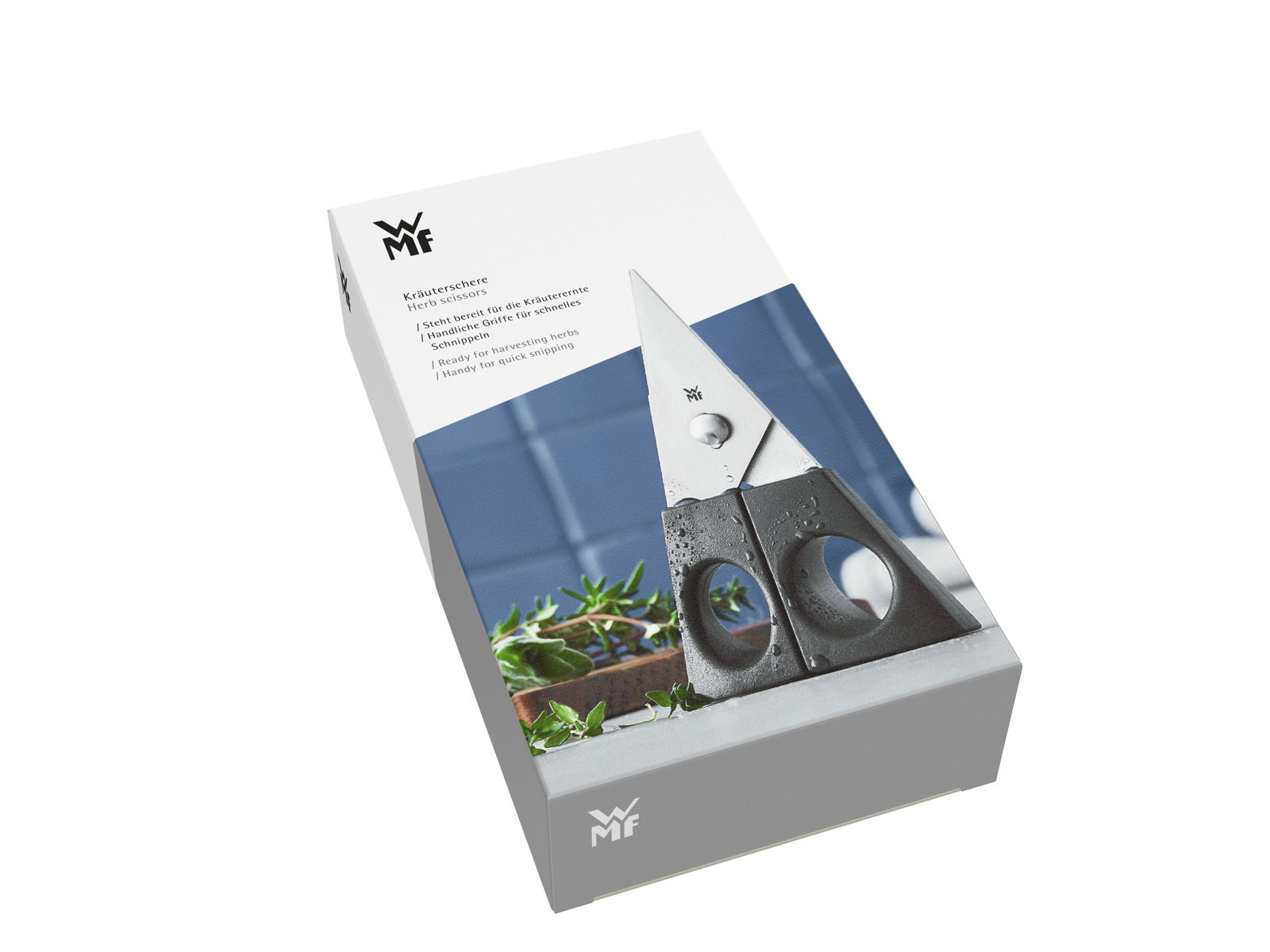 Verpackung der Kräuterschere 13cm schwarz von WMF, schräg von oben fotografiert, zeigt die Schere und frische Kräuter.