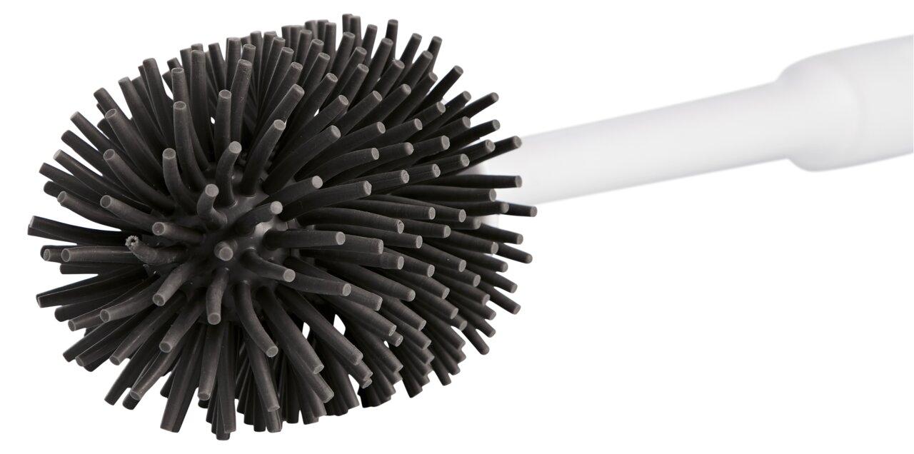 Nahaufnahme einer Toilettenbürste mit schwarzem, flexiblem Bürstenkopf und weißem Griff, seitliche Perspektive