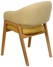 Achterkant van een gele fauteuil met houten poten