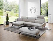 Moderne Hockerbank in einem hellen Wohnzimmer mit großen Fenstern, die einen Blick auf einen grünen Garten bieten. Perspektive von vorne.