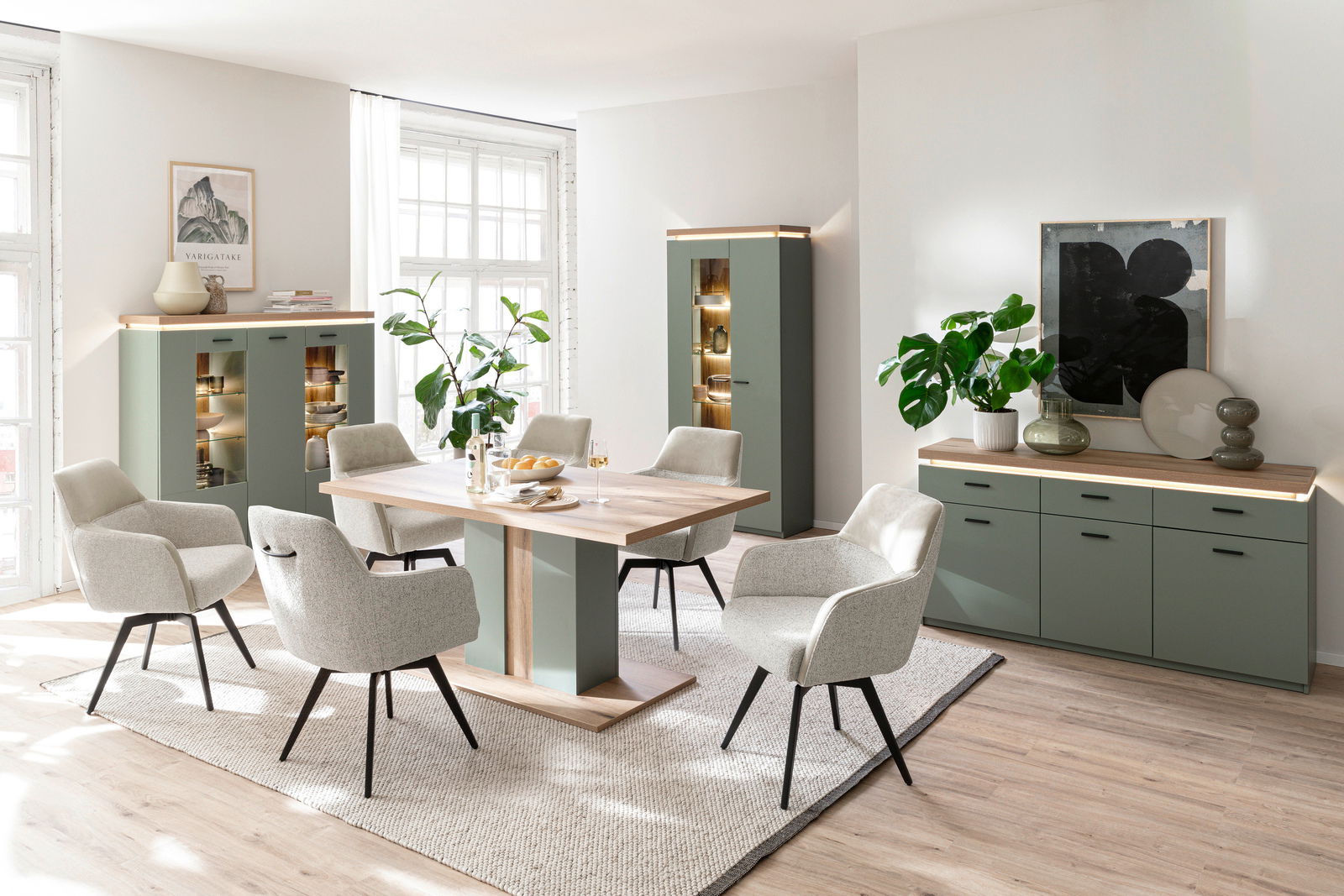Z2 Hoog dressoir MONIZ Esszimmer mit modernem Highboard und Sideboard in grünem Design, umgeben von eleganten Stühlen und einem Esstisch aus Holz. Perspektive: Frontalansicht.