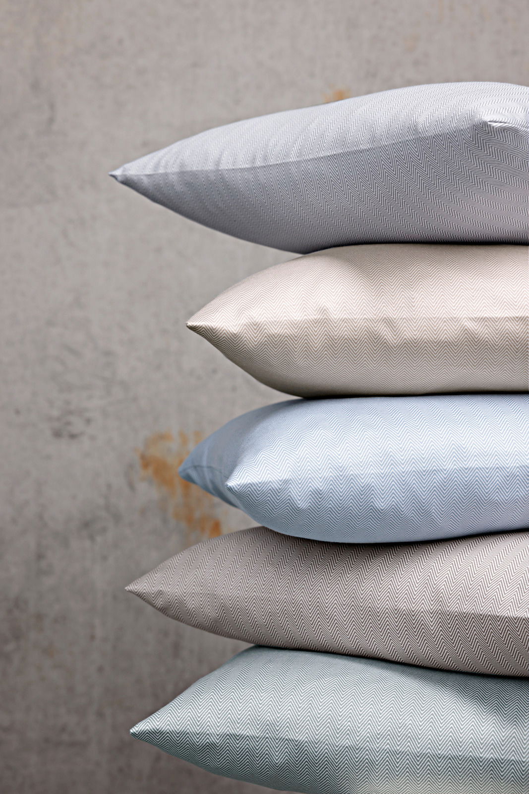 Stapel von Kissenbezügen in verschiedenen Farben und Mustern, seitliche Perspektive