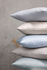 Stapel von Kissenbezügen in verschiedenen Farben und Mustern, seitliche Perspektive