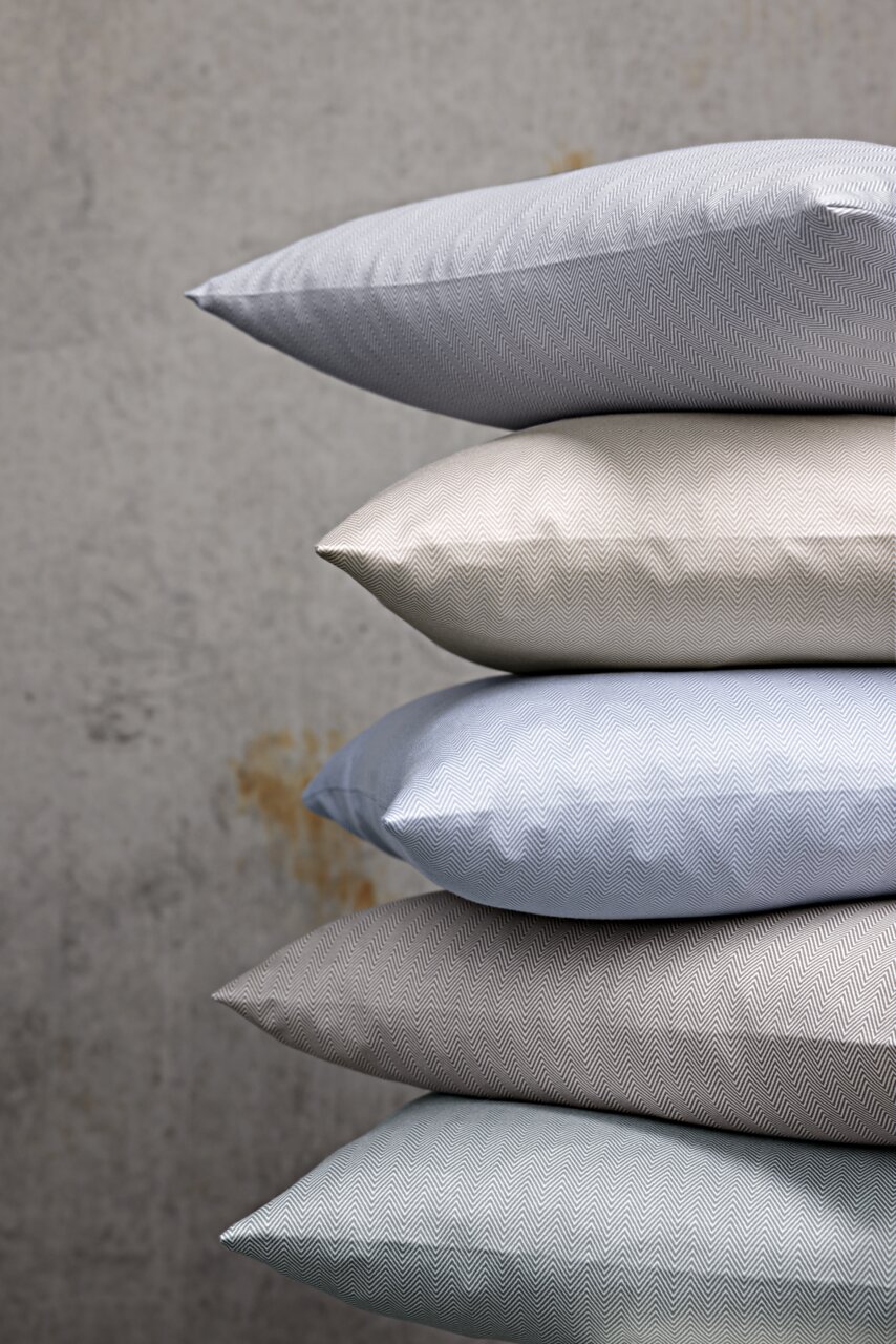 Stapel von Kissenbezügen in verschiedenen Farben und Mustern, seitliche Perspektive