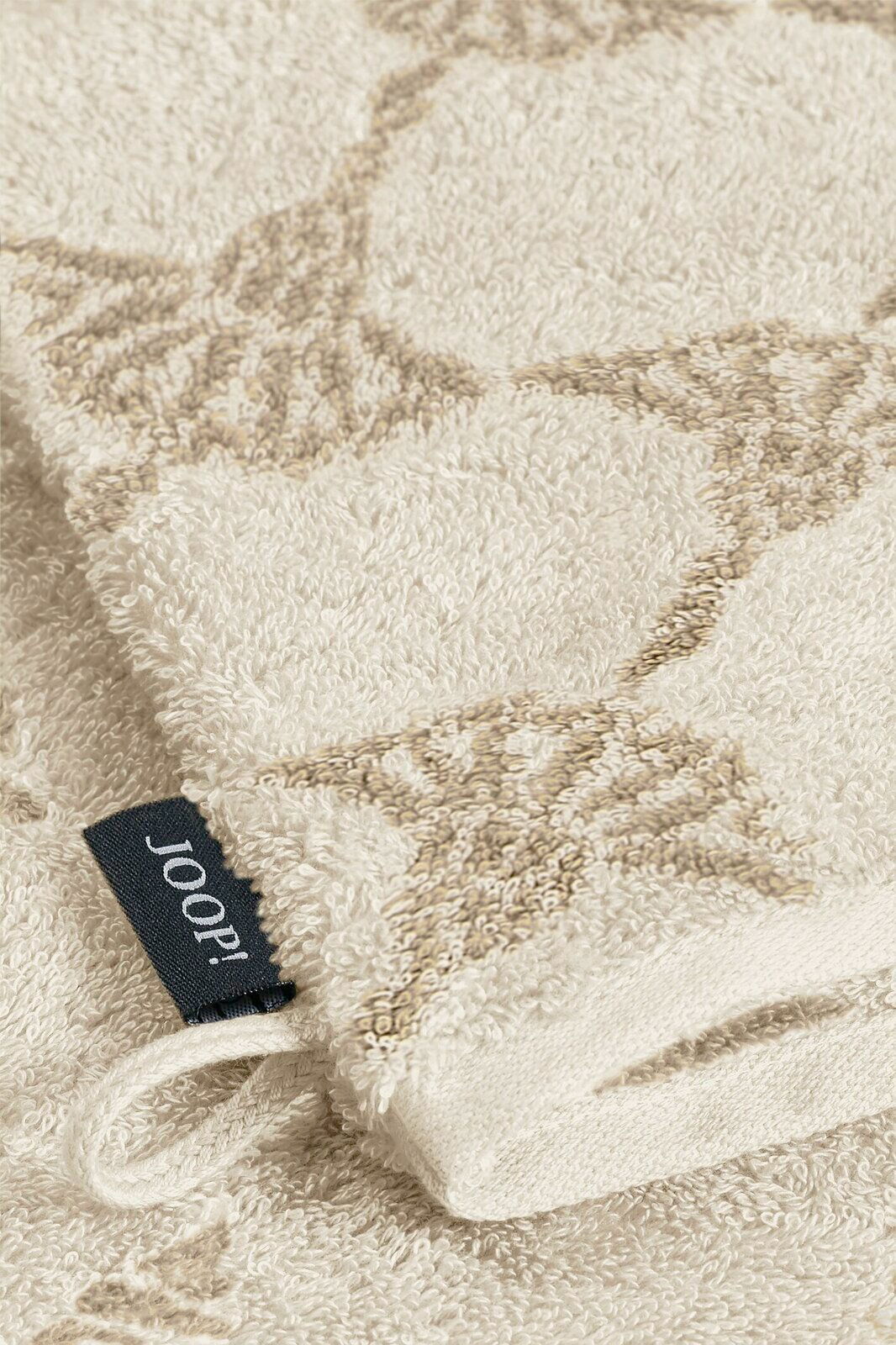 JOOP! Waschhandschuh Nahaufnahme eines beigen Waschhandschuhs mit dezentem Muster und einer schwarzen Joop!-Markenlasche.