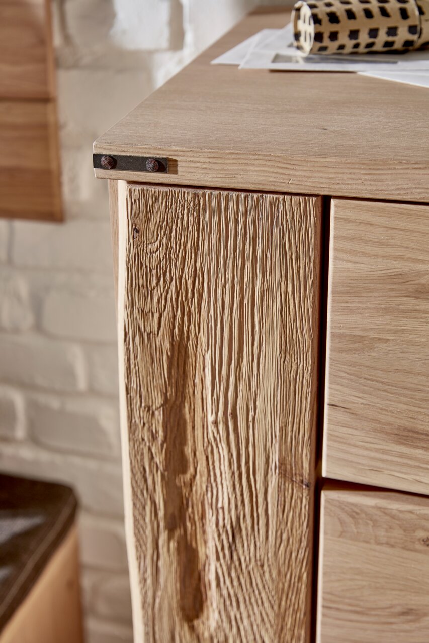 Detailansicht eines Schuhschranks aus Holz mit rustikaler Maserung und Metallbeschlägen.