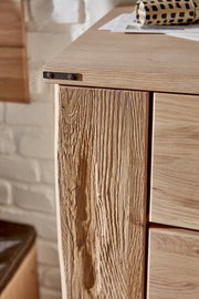 Detailansicht eines Schuhschranks aus Holz mit rustikaler Maserung und Metallbeschlägen.
