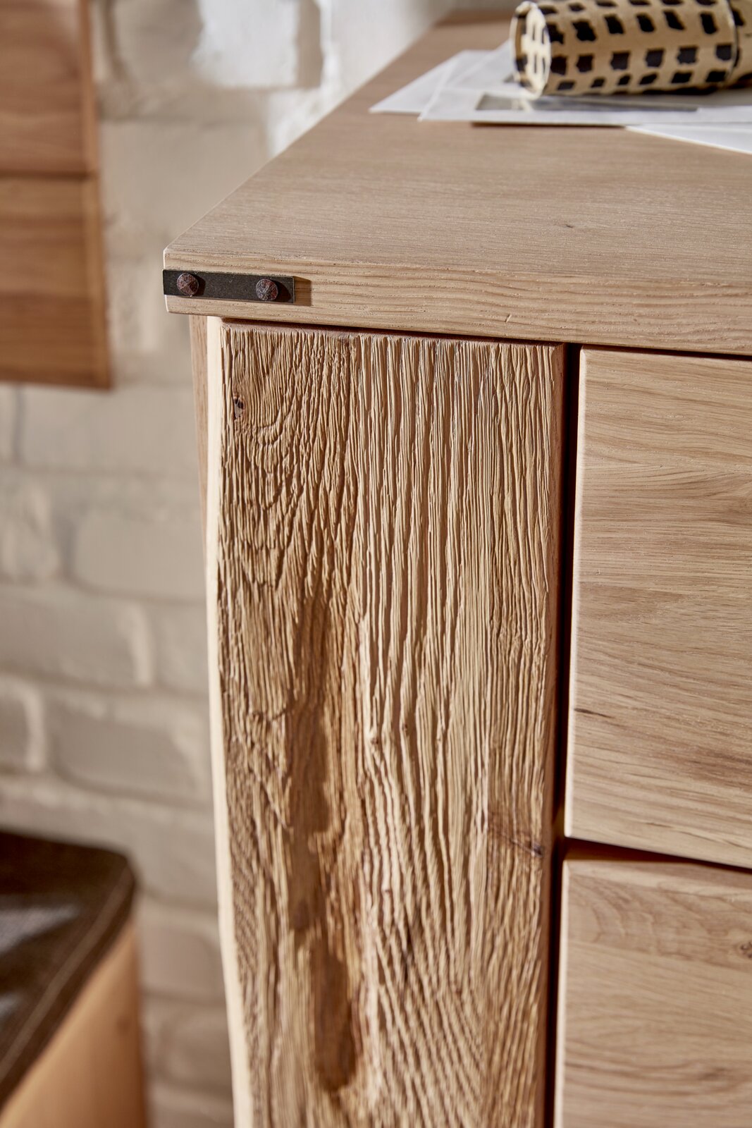 Detailansicht eines Schuhschranks aus Holz mit rustikaler Maserung und Metallbeschlägen.
