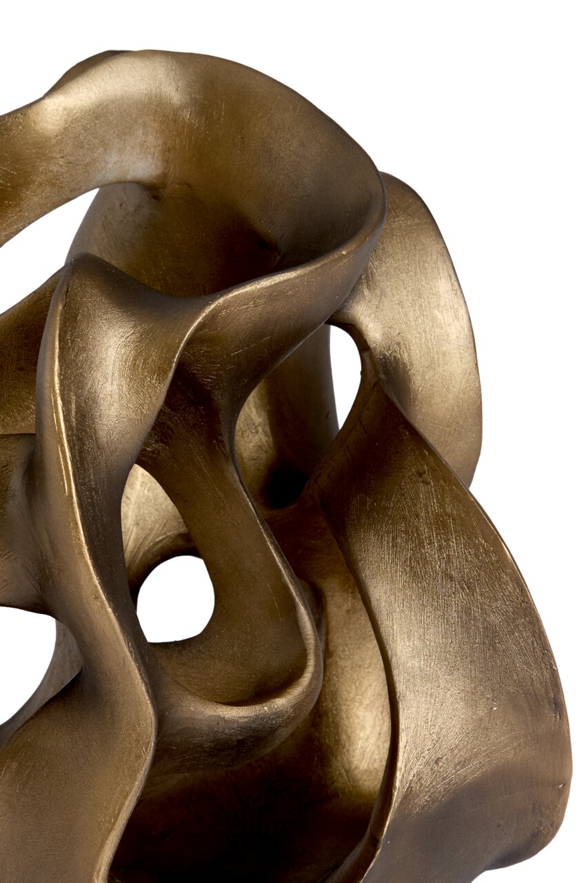 Close-up van een goudkleurig, abstract ornament met gebogen vormen en openingen.