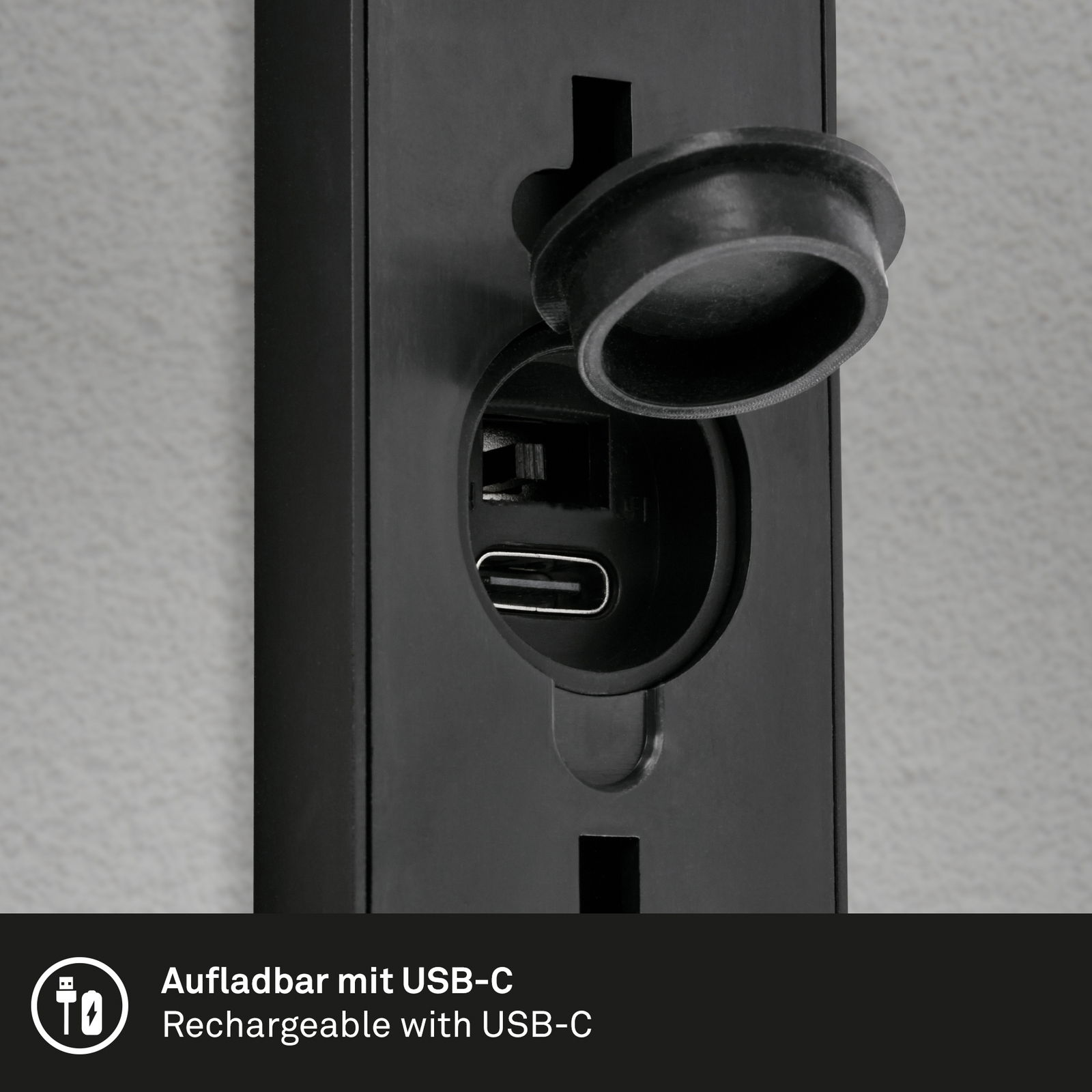 Nahaufnahme einer schwarzen Akku-Außenwandleuchte mit USB-C-Anschluss, perspektivisch von der Seite aufgenommen.