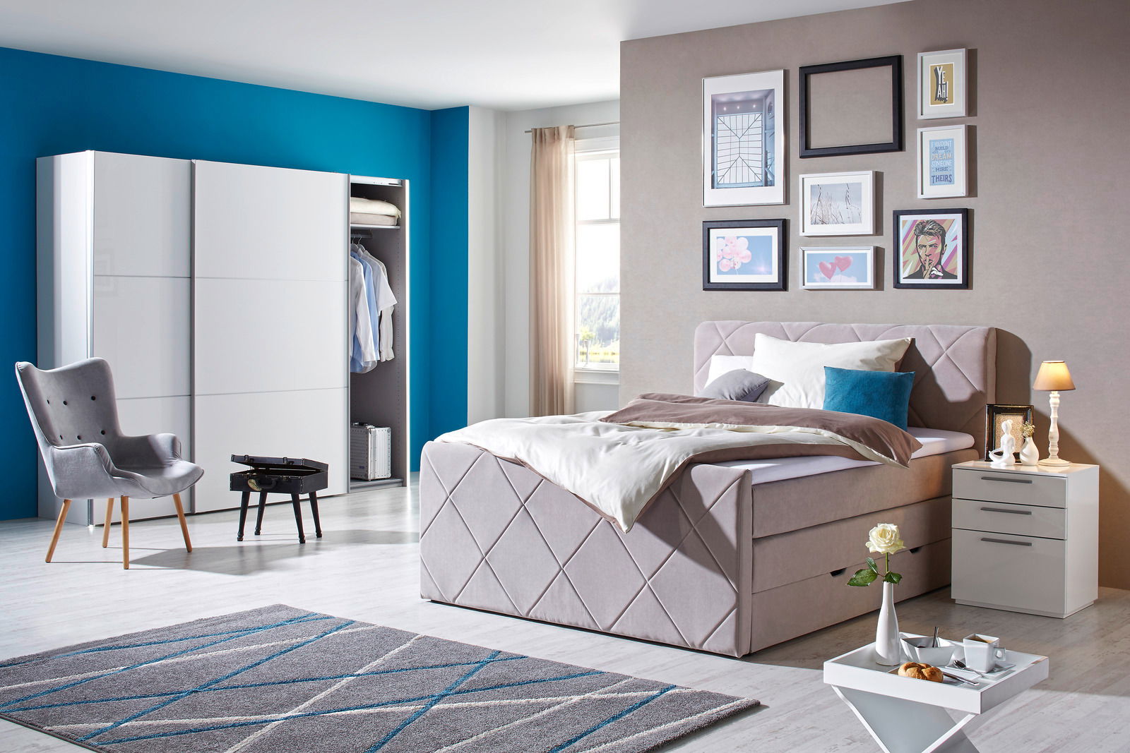 Modernes Boxspringbett in einem stilvoll eingerichteten Schlafzimmer, seitliche Perspektive mit dekorativen Kissen und Nachttisch.