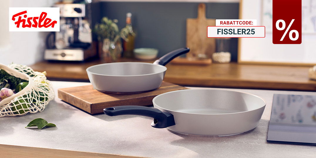 Zwei helle Fissler-Bratpfannen mit schwarzen Griffen auf moderner Küchenarbeitsplatte