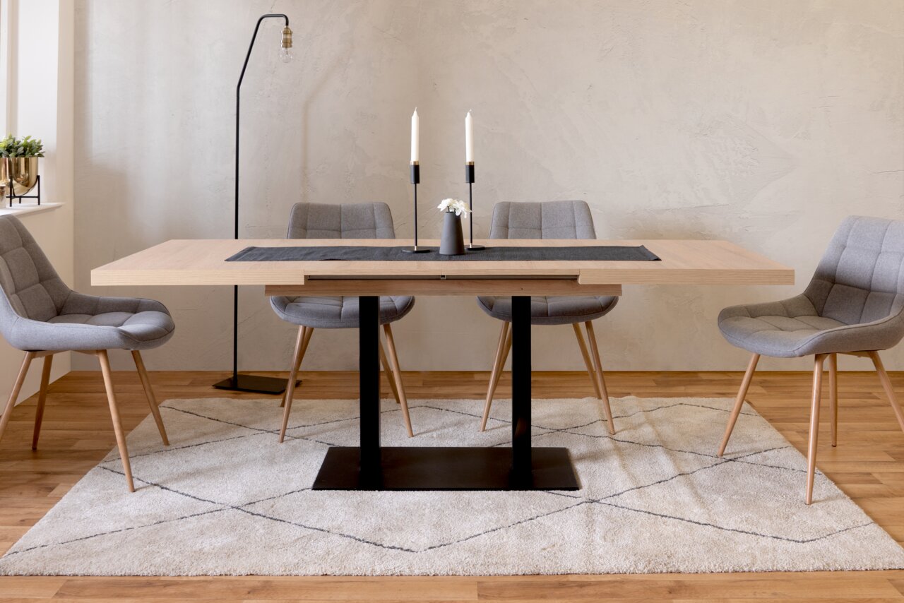 Moderner Esstisch QUADRATO mit hellem Holz und schwarzem Metallgestell, umgeben von grauen Stühlen, aus frontaler Perspektive fotografiert.