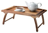 Holz-Betttablett mit klappbaren Beinen, darauf eine weiße Teekanne und eine Tasse Tee, seitliche Perspektive