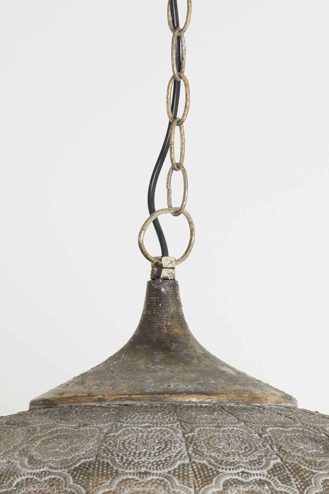 Detailansicht einer Hängeleuchte mit antikem Finish und dekorativem Muster, von unten fotografiert.