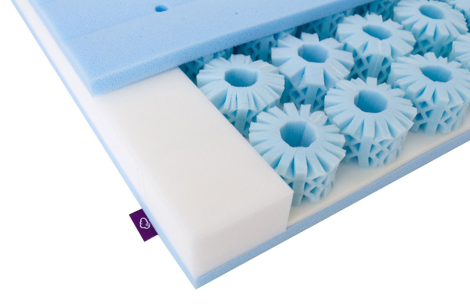 Nahaufnahme einer Matratze mit blauen Schaumstoffelementen und weißem Schaumstoff, perspektivisch von oben fotografiert.
