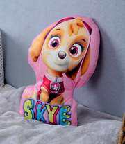 Skye-Formkissen mit buntem Skye-Motiv aus einer Kinderfernsehserie, auf einem Bett platziert, seitliche Perspektive.