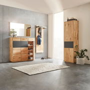 Moderne Garderobeneinrichtung mit Holzschränken, Spiegel und Teppich in einem hellen Raum, seitliche Perspektive