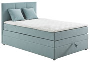 Boxspringbett in hellblauem Stoffbezug mit zwei Kissen, seitliche Perspektive