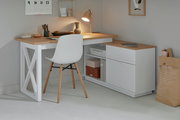 Moderner Eck-Schreibtisch in Holzoptik mit weißem Gestell, seitlicher Schubladenkommode und dekorativer Beleuchtung, aus der Perspektive eines gemütlichen Arbeitszimmers.