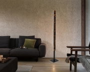 Moderne LED-Stehleuchte in einem gemütlichen Wohnzimmer, seitliche Perspektive